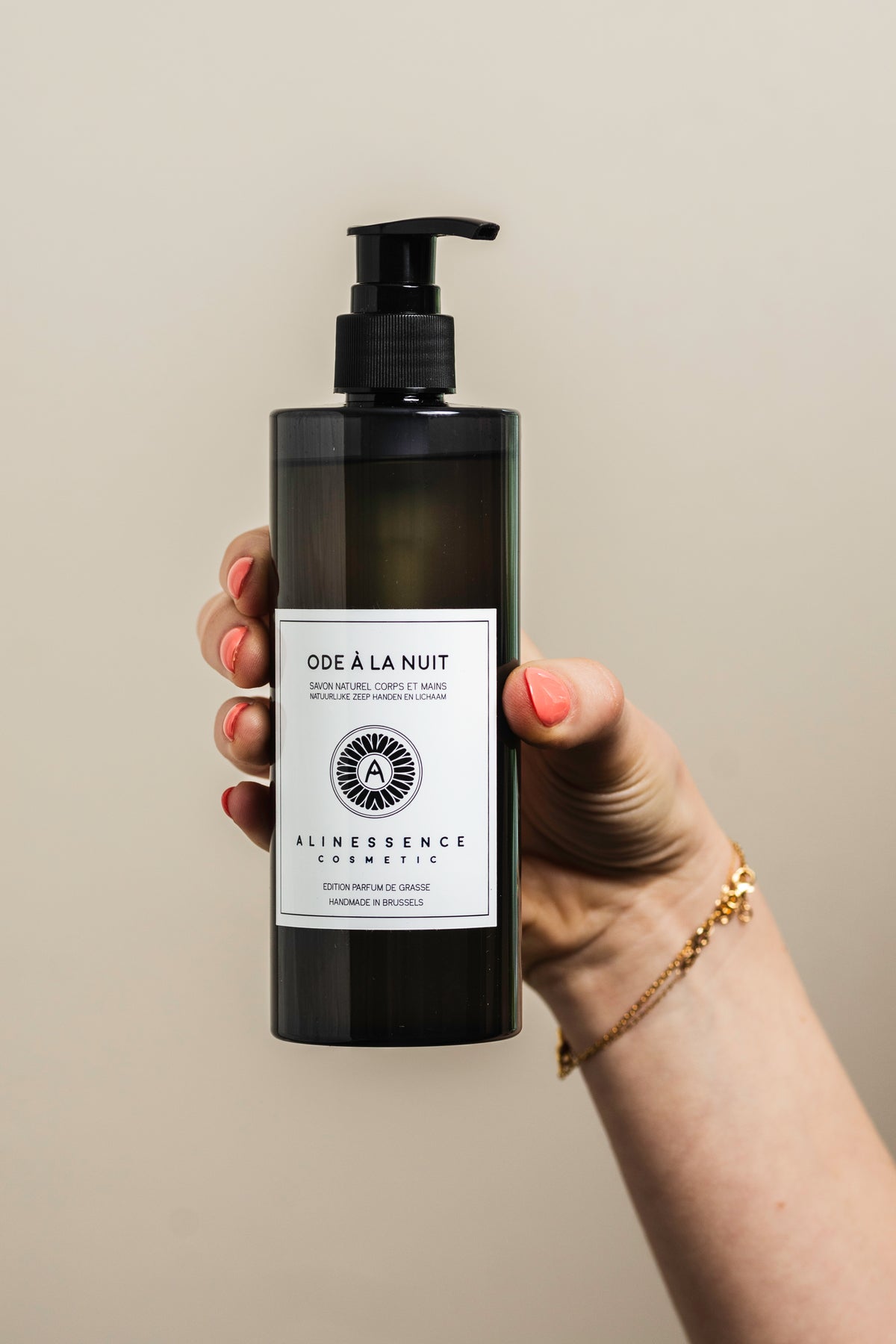 Flacon pompe de savon naturel corps liquide Ode à la Nuit par Alinessence Cosmetic, tenu à la main